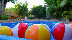 漂浮在游泳池中的彩色海滩球17秒视频
