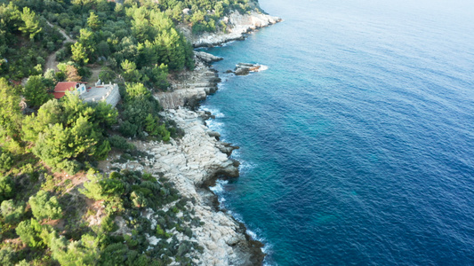 无人驾驶无人驾驶飞机飞越岩石海岸线与松绿的海水连在一起视频