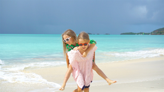 在热带海滩玩得开心的小女孩一起玩耍慢动作视频
