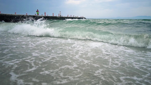 风浪海浪中的旧码头缓慢地在沙滩沙滩上喷洒视频