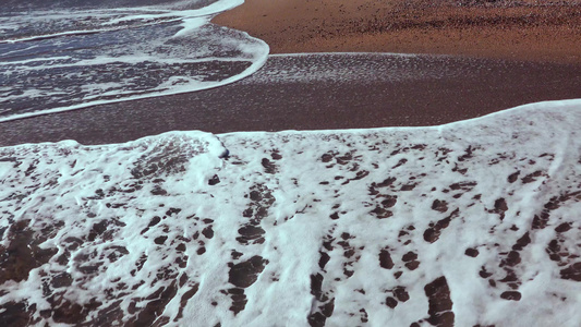 海浪沙滩上有白泡沫卷太阳在水中的反射黑海视频