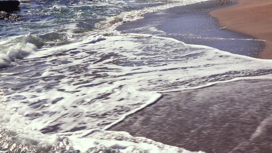 海浪沙滩上有白泡沫卷太阳在水中的反射黑海视频