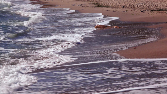 海浪沙滩上有白泡沫卷太阳在水中的反射黑海视频