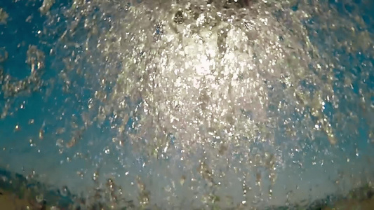 沙滩淋浴水滴落在摄像机上向蓝天慢动作视频