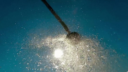 沙滩淋浴水滴落在摄像机上向蓝天慢动作视频