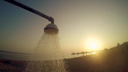 夏夏沙滩淋浴水在日落的阳光下倾注缓慢运动视频