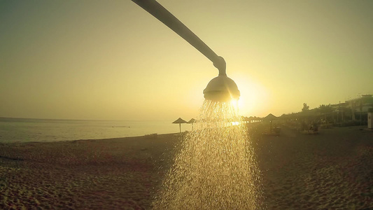 夏夏沙滩淋浴水在日落的阳光下倾注缓慢运动视频