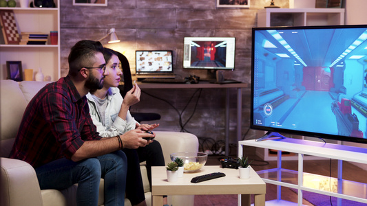 男人坐在沙发上在电视上玩电子游戏视频