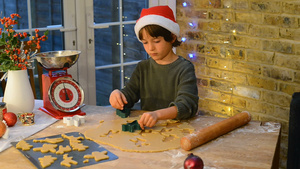 男孩戴着圣诞帽在家里做圣诞饼干22秒视频