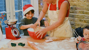男孩戴着圣诞帽在和妈妈一起家里做圣诞饼干11秒视频