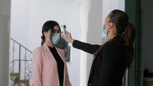 身戴面罩检查工人温度的caucasian女性视频
