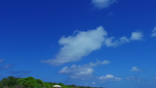 以度假村附近的蓝绿色海洋和白沙背景复制美丽度假村海滩视频