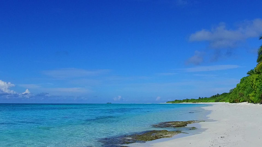 以蓝水和白色沙滩背景在海浪附近进行风光晴朗的旅游旅游视频