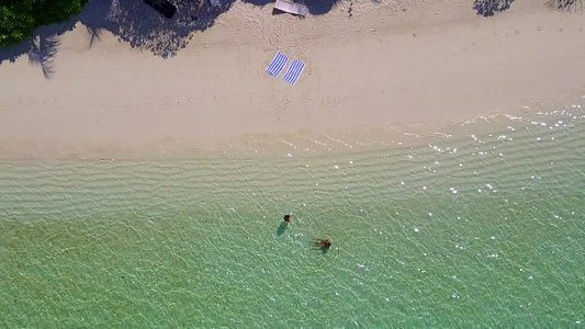 日出后蓝海和白色沙滩背景的天堂湾海滩历险空旷景色视频