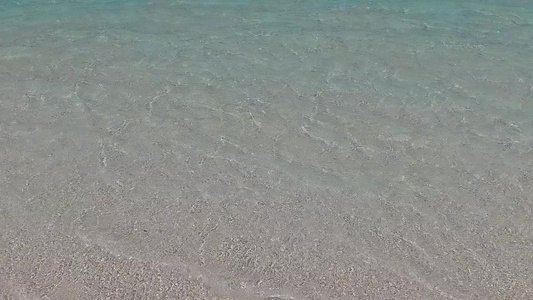 蓝色海洋和冲浪附近的白色沙滩背景下美丽的海岸线海滩视频