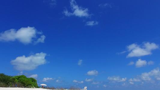 日出后蓝色环礁湖和白色沙滩背景的长宽角海滨海滩旅程视频