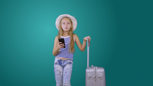带旅行手提箱和手机的旅游女游客绿背景在外视频