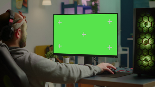 游戏玩家在具有绿屏桌面的功能强大的计算机上玩视频游戏视频