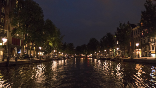 夜间在Amsterdam运河上游船超过时间视频