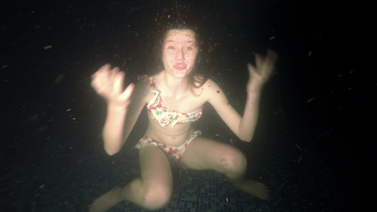 小女孩潜入黑暗的水中展示了这些手势视频