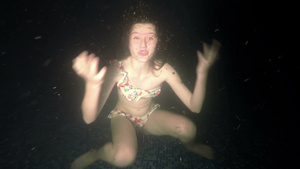 小女孩潜入黑暗的水中展示了这些手势10秒视频
