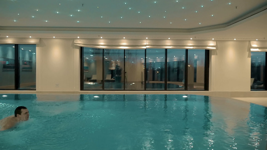 男人独自在室内游泳池里游泳视频