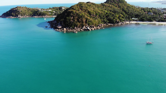 在热带海岸附近的小船现代游艇在热带火山岛海岸附近平静视频