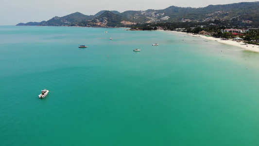 现代摩托游艇漂浮在阳光明媚的热带度假胜地海滩附近的视频