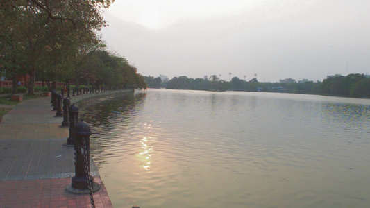 夏日傍晚的湖边公园日落阳光照亮的花园小径公园车道风景视频