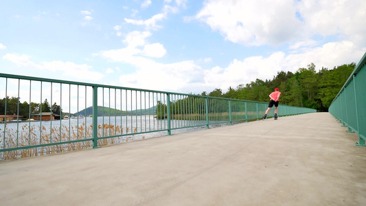 身穿红色t恤和黑色裤子的直排轮滑运动员在桥上滑冰的视频