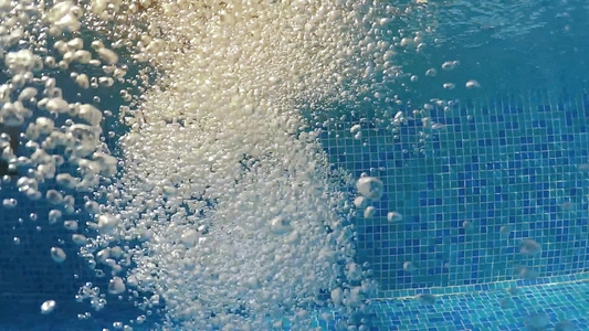 气泡上升到表面慢动作游泳池清澈蓝色水中的气泡水下拍摄视频