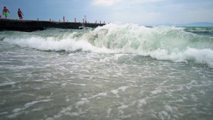 自然背景海浪在海滩沙滩上喷洒在背景中从码头看岸边慢动作30秒视频