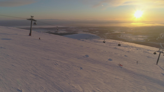 在阳光明媚的冬日夕阳下人们在滑雪坡上滑雪和滑雪板滑雪视频