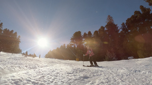 在下山坡滑雪的小女孩冬季运动娱乐活动;以及30秒视频