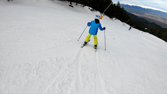 滑雪冬天滑雪假期小男孩滑雪下来在山腰的乐趣慢动作视频