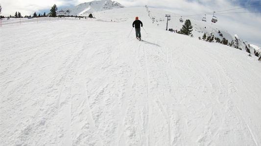 高山滑雪胜地前视慢动作在高山脚底的悬崖上骑滑雪车视频
