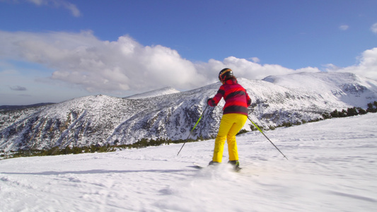 在阳光明媚的一天在斜坡上滑雪的中产女性滑雪者视频