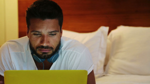 躺在床上拿着黄色笔记本电脑的男人10秒视频
