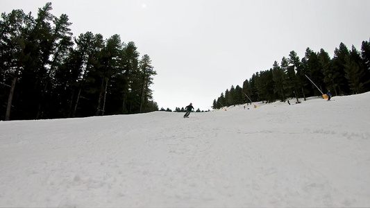 前视跟踪滑雪者用橙色头盔缓慢地从滑雪坡下划下来视频