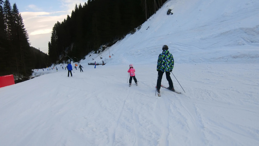 父亲和孩子在冬日的滑雪道上视频