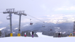 山坡上的滑雪机和滑雪机在乌斯特雷贝茨快轮椅上雾与风25秒视频