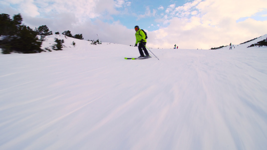 在接近一天末的斜坡上滑雪的男性滑雪者视频