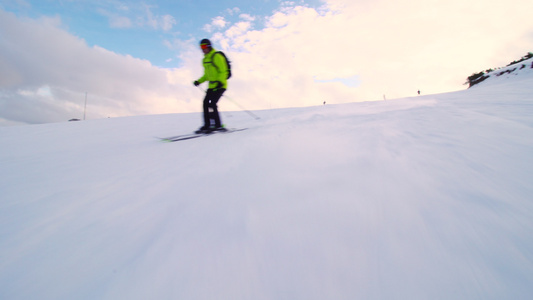 在接近一天末的斜坡上滑雪的男性滑雪者视频
