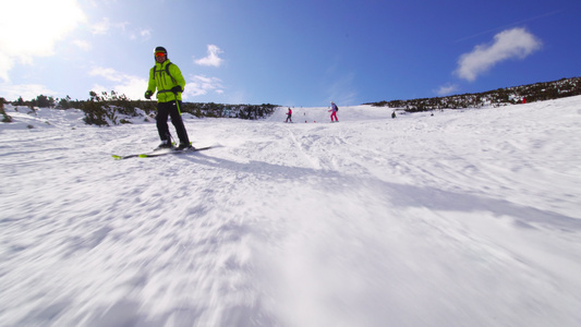 在阳光明媚的一天在斜坡上滑雪的男性滑雪者视频