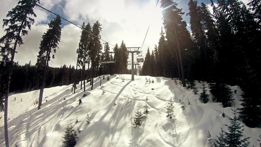 日出时在阳光明媚的冬季日子里滑雪者骑着椅子升降机慢动作视频