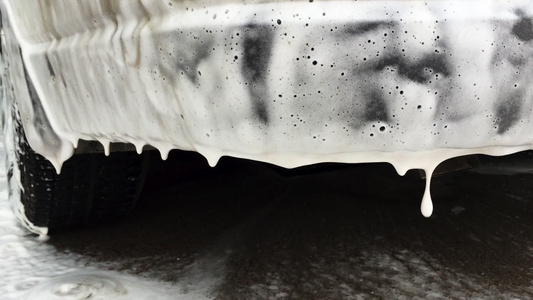 脏洗车的白色泡沫泡沫泡泡在地板洗发水上滑落清洗视频
