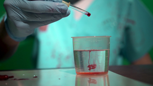 非法秘密医学实验室用移液管滴红血液溶解在烧杯量杯中视频