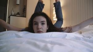 年轻女士躺在床上看着摄像机19秒视频