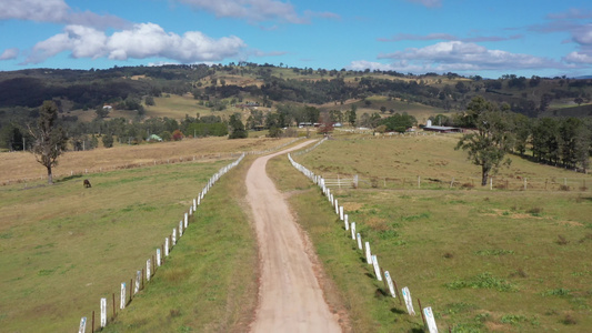 Australia地区一条带白色栅栏的泥土道路的空中视频