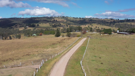 Australia地区一条带白色栅栏的泥土道路的空中视频